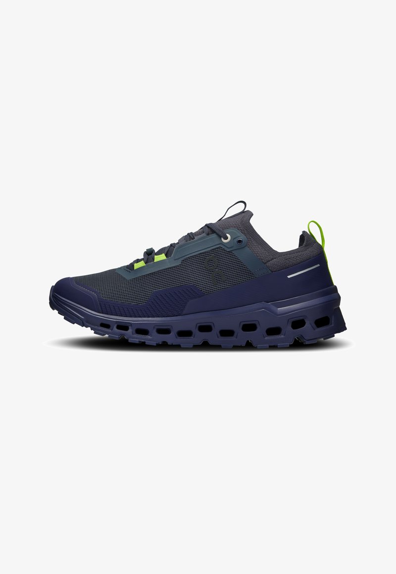 Chaussure de course avec une tige en maille bleu foncé et des accents vert lime, semelle extérieure en caoutchouc texturé et midsole rembourrée avec des trous de ventilation.