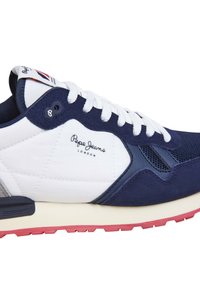 Marineblå och vit sneaker med mocka och meshpaneler, gummisula, snörning och präglad logotyp på sidan. Har röda detaljer på sulan.