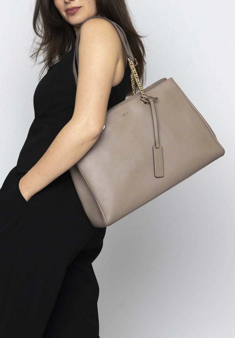 Beige Ledertasche mit strukturierter Oberfläche, silbernen Kettenriemen und abnehmbarem Anhänger. Rechteckige Form mit Reißverschluss.