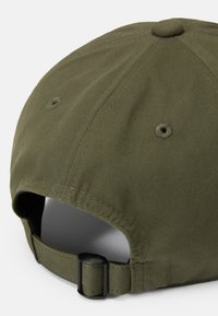 Olive green baseball cap with a fabric texture, stitched detailing, and a black adjustable strap at the back. Reinforced eyelet vents visible.