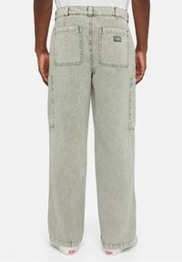 Světlé zelené cargo kalhoty s volným střihem, vybavené dvojitými zadními kapsami, bočními kapsami a texturovaným vzhledem.