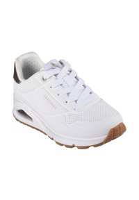 Scarpa atletica bianca con design perforato, sistema di allacciatura e suola in gomma; presenta un'imbottitura ad aria e un accento in metallo con logo.