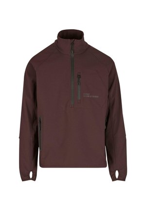 Burgundy pullover-takki sileässä kankaassa, jossa on korkea kaulus, vetoketjullinen rintatasku, sivuvetoketjut ja peukalonreiät hihansuissa.