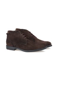 Stivali alla caviglia in suede marrone con punta tonda, lacci frontali e una suola in gomma nera liscia. Dettagli di cucitura discreti e un piccolo logo in evidenza.