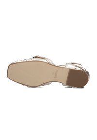 Gouden metallic sandaal met een gestructureerd bandontwerp, vlakke zool en een kleine gespsaccent. De zool heeft verhoogde tractie voor grip. Maat 38.