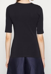 Svart kortärmad t-shirt i bomullsblandning, har rund hals och kroppsnära passform, med en jämn textur och ren fåll.