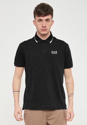 Polo shirt nera in cotone, con apertura a due bottoni, dettagli a righe bianche sul colletto e logo sul petto.