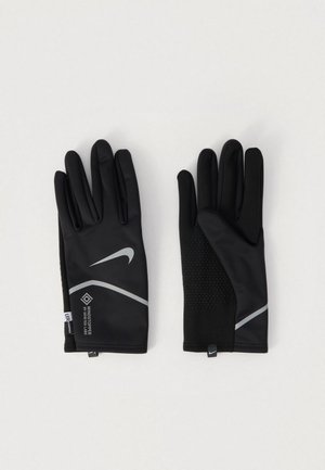 Black winter gloves with reflective Nike swoosh and Windstopper by Gore-Tex Labs logo, textured grip on palm side, laid flat on white background.