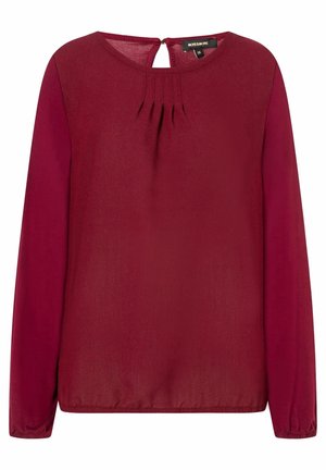 Burgundy long-sleeve blouse with round neckline, pleated front detail, and a small keyhole opening at the back. Smooth fabric texture.