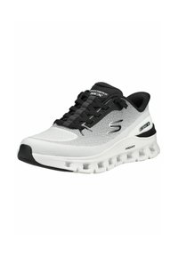 Chaussure de sport Skechers Arch Fit blanche et noire avec semelle coussinée et design à lacets, présentée en angle sur un fond blanc.