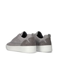 Een paar grijze suede en leren sneakers met witte rubberen zolen, weergegeven vanaf de achterkant en schuin naar de zijkant.
