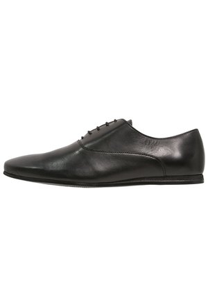 Schwarze Lederformalschuhe für Herren mit Schnürung, elegantes Design und niedriger Absatz, seitlich auf einem weißen Hintergrund dargestellt.