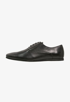 Chaussure de ville pour homme en cuir noir, avec lacets, au design élégant et au talon bas, présentée en vue latérale sur un fond blanc.