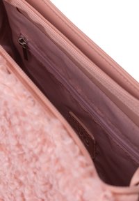 Pochette rosa testurizzata con un esterno morbido e peloso. L'interno presenta una tasca con zip e un rivestimento liscio. Design compatto per piccoli oggetti.