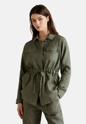 Camisa de lino verde oliva con un corte relajado, que cuenta con una cintura ajustable con cordón, dos bolsillos en el pecho y cierre frontal con botones. Mangas largas.