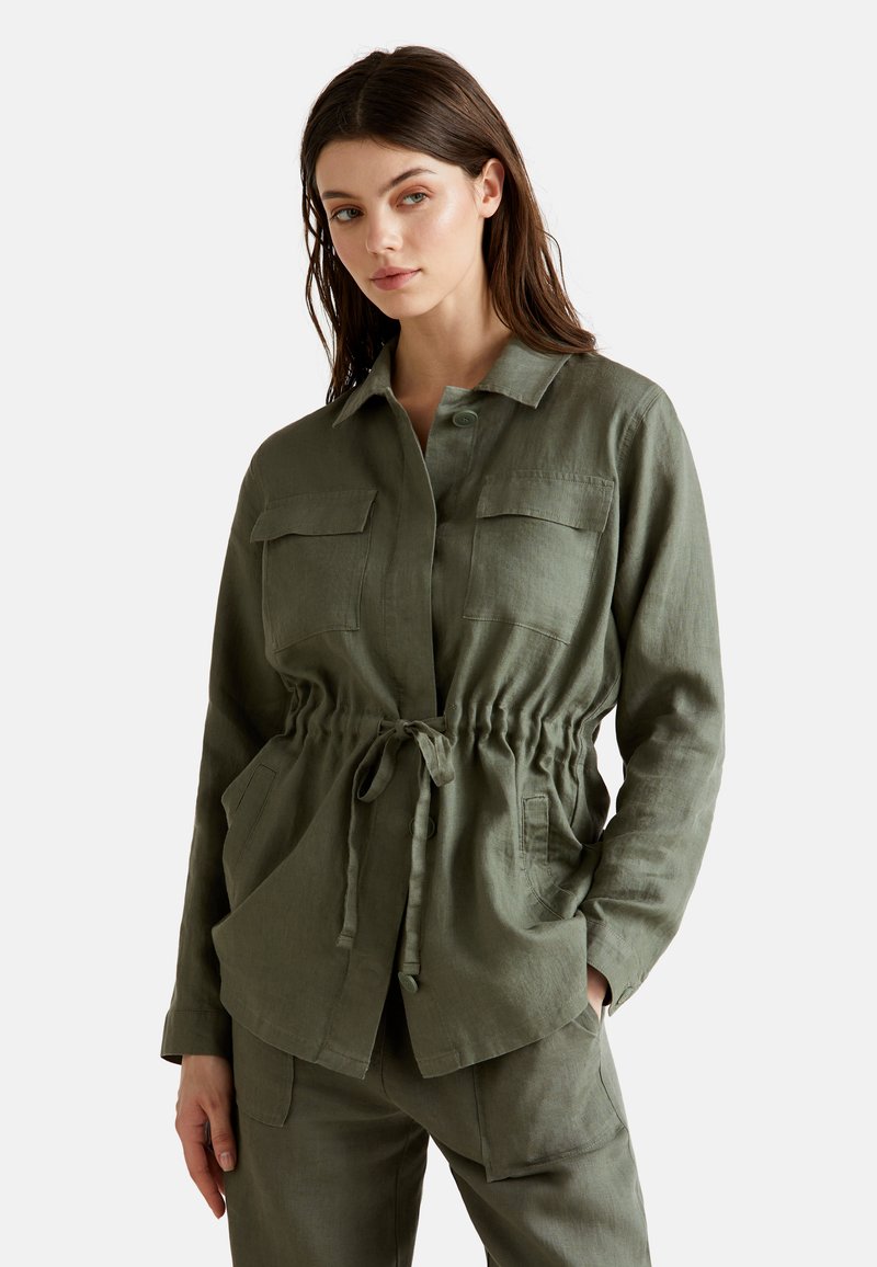 Chemise en lin vert olive avec une coupe décontractée, dotée d'une taille à cordon, de deux poches poitrine et d'une fermeture à bouton. Manches longues.