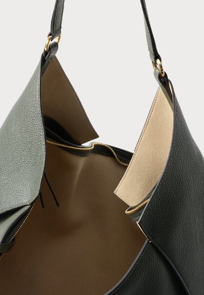 Green leather tote bag with a textured exterior and gold hardware. Open top reveals a smooth beige interior and zippered compartment.
