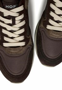 Dark brown sneakers with suede and fabric textures, beige laces, white soles, and "HOFF" branding on the tongue.