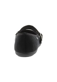Zapato de tela negra con tacón plano, detalle de correa y parte trasera acolchada. El exterior es suave con una punta ligeramente redondeada.