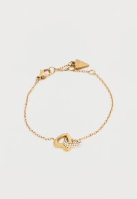 Βραχιόλι αλυσίδας από χρυσό με καρδιά σε σχήμα συνδέσμου, διακοσμημένο με μικρές διαφανείς πέτρες, με κούμπωμα αστακού και ετικέτα μάρκας.