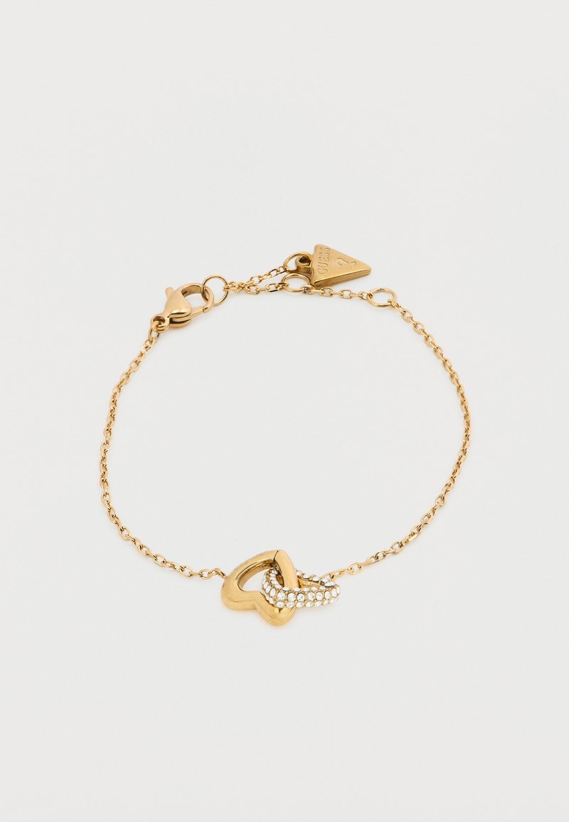Βραχιόλι αλυσίδας από χρυσό με καρδιά σε σχήμα συνδέσμου, διακοσμημένο με μικρές διαφανείς πέτρες, με κούμπωμα αστακού και ετικέτα μάρκας.