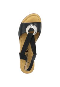 Schwarze Leder-Sandale mit einem runden silbernen Akzent, elastischen Riemen und einer weichen beigefarbenen Fußbett. Mit kontrastierenden Nähten entlang der Kanten.