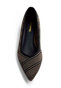 Chaussure plate à bout pointu avec un dessus en tricot noir et beige à rayures diagonales et des rehauts noirs, vue d'en haut.