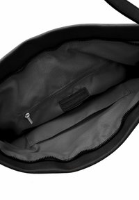Black leather handbag interior featuring a zippered pocket, smooth fabric lining, and a brand label. Pouch design with curved edges.