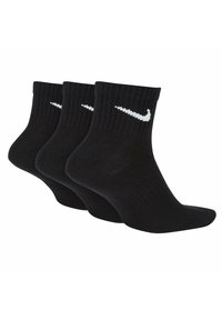 Calze alla caviglia in cotone nero con design a coste, dotate di logo bianco Nike sulla parte anteriore. La confezione include tre paia.