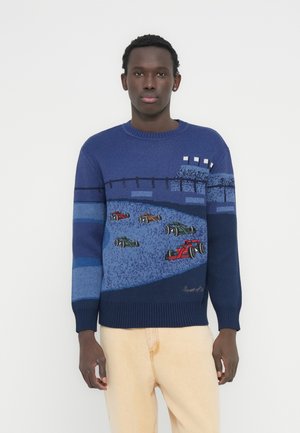 Μπλε σκούρο πουλόβερ με ριμπ λαιμόκοψη και υφασμάτινο μοτίβο. Διαθέτει κεντημένα αγωνιστικά αυτοκίνητα σε κόκκινο, πράσινο και μαύρο, με οριζόντιες ρίγες.