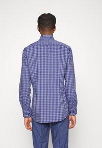 Camicia a maniche lunghe con bottoni in un motivo a griglia blu e bianco, dotata di colletto e polsini con bottoni, realizzata in un tessuto a trama liscia.