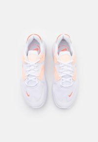 Białe buty sportowe z siateczką i skórzanymi akcentami, z pomarańczowymi detalami, zaokrąglonym noskiem i płaskimi sznurowadłami. Gładka faktura i wyściełany kołnierz.