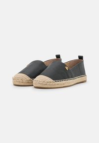 Espadrilles de cuero negro con suela de yute trenzado, punta redonda y pequeña lengüeta trasera. Acento de logo dorado en el costado.