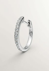 Pendiente de aro plateado con un diseño curvado, que presenta una línea de pequeñas piedras transparentes a lo largo del borde frontal. Acabado metálico suave.