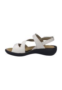 White leather sandal with an open toe design, multiple cross straps, and a black rubber sole, featuring a slight wedge heel.