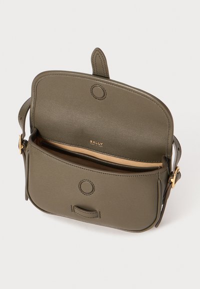 Sac à main en cuir vert olive avec une fermeture à rabat, accents en métal doré, et un compartiment principal révélant une doublure beige.