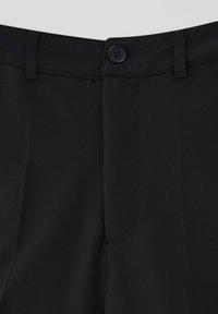 Mustat suorat housut, joissa on yksinkertainen nappikiinnitys ja vyölenkit. Sileä pinta ja räätälöity istuvuus korostavat siistejä linjoja.