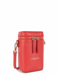 Borsa a tracolla in pelle rossa con texture, hardware dorato, chiusura a zip e frange decorative. Presenta il logo "Lancaster Paris" impresso.