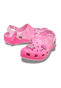 Crocs rosa realizzati in materiale leggero, con fori di ventilazione, superficie texturizzata e charm decorativi tra cui una palma e un rossetto.