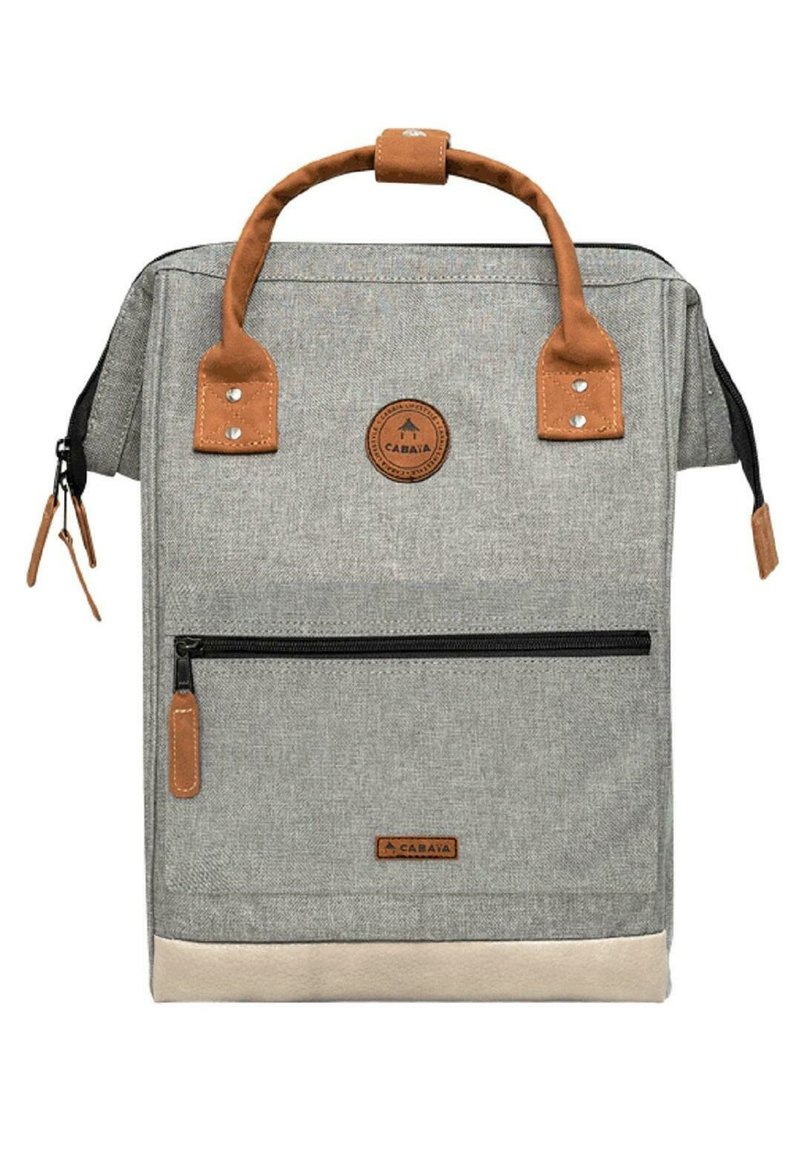 Grau canvas Rucksack mit braunen Lederakzenten, einem oberen Griff, einer frontalen Reißverschlusstasche und einem runden Logo-Patch. Der untere Abschnitt hat eine beigefarbene Einfassung.