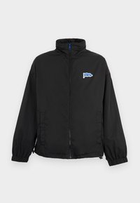 Veste noire zippée avec poignets élastiques, col montant, poches latérales et petit logo "HUGO" bleu et blanc sur la poitrine gauche.