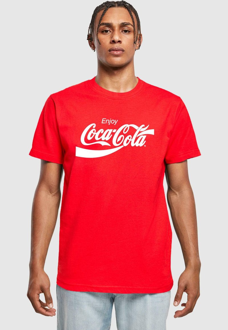 Červené bavlněné tričko s nápisem "Užijte si Coca-Colu" v bílé kurzívě přes hrudník. Krátké rukávy, kulatý výstřih a pohodlný střih.