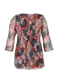 Blouse rouge transparente à manches longues avec imprimé floral multicolore, tissu texturé et col rond.