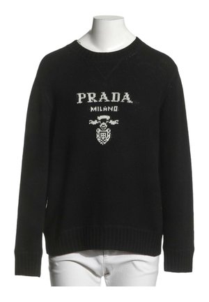 Czarny sweter z długim rękawem z białym napisem "PRADA MILANO" i logo na piersi, prezentowany na białym torsie manekina.