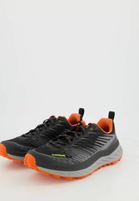 Svarta träningsskor med orange detaljer, med en texturerad ovandel, stödjande sula och en slank design för prestanda.