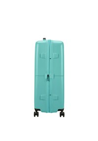 Turkoosi matkalaukku, jossa on teksturoitu pinta, kaksoissalpa ja neljä mustaa pyörää liikkuvuuden parantamiseksi. Erittäin kestävä muotoilu ja ergonominen kahva.