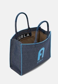 Denimová taška přes rameno s modrými akcenty, vyznačující se výrazným modrým logem, dvěma pevným uchy a odolnou podšívkou, prostorným interiérem s kapsou na zip.