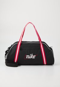 Black duffel bag with red and white striped handles, smooth texture, zippered closure, and embroidered Nike logo on the front.