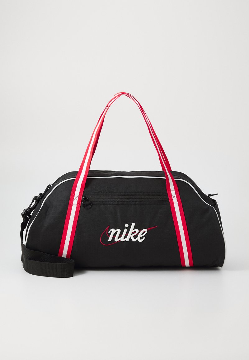 Black duffel bag with red and white striped handles, smooth texture, zippered closure, and embroidered Nike logo on the front.