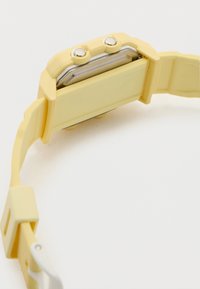 Κίτρινο ψηφιακό ρολόι χειρός με δύο μεταλλικά κουμπιά στο πλάι και πλαστικό ρυθμιζόμενο λουράκι σε λευκό φόντο.